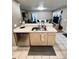 Open-concept kitchen with marble countertop, stainless steel sink, and eat-in bar at 5051 Nw 61St Ct, Ocala, FL 34482