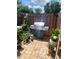Enclosed brick backyard featuring a stainless steel grill and lovely potted plants near a wooden fence at 508 Villa Del Sol Cir # 105, Orlando, FL 32824