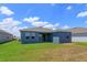 A well maintained backyard features ample grass, a patio and blue home exterior, perfect for outdoor enjoyment at 520 Silver Palm Dr, Haines City, FL 33844