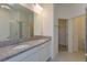 Bathroom with dual sinks, granite countertop, a mirror with lighting, and a separate shower with a glass door at 520 Silver Palm Dr, Haines City, FL 33844