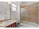 Bathroom features a vanity with sink, commode, and shower-tub combination with glass doors at 541 Cokesbury Dr, The Villages, FL 32162