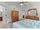 Bright bedroom featuring a ceiling fan, closet, dresser, and comfortable bedding in a neutral color palette at 541 Cokesbury Dr, The Villages, FL 32162
