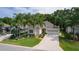 Aerial view of a charming single-story home with a well-manicured lawn and lush landscaping with palm trees at 541 Cokesbury Dr, The Villages, FL 32162