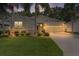 Inviting home with a well-lit driveway, lush landscaping, and a charming facade during twilight hours at 541 Cokesbury Dr, The Villages, FL 32162