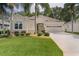 Charming single-story home with a well-manicured lawn and lush landscaping with palm trees at 541 Cokesbury Dr, The Villages, FL 32162
