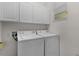 Functional laundry room with washer, dryer, overhead cabinets, and bright lighting at 541 Cokesbury Dr, The Villages, FL 32162