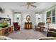 Comfortable living room with a ceiling fan, large windows, and a mix of seating options, including a recliner at 541 Cokesbury Dr, The Villages, FL 32162