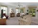 Bright living room featuring varied seating options, a ceiling fan, and access to an enclosed outdoor patio at 541 Cokesbury Dr, The Villages, FL 32162