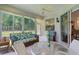 Inviting sunroom with a glass-top table, comfortable seating, and natural light streaming through the sliding glass doors at 541 Cokesbury Dr, The Villages, FL 32162