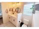 Modern bathroom with double sinks, round mirrors, and white cabinetry for ample storage at 591 Black Eagle Dr, Groveland, FL 34736
