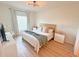 Bright bedroom features a queen-size bed, wood floors, and modern ceiling fan at 591 Black Eagle Dr, Groveland, FL 34736