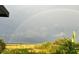 Vibrant rainbow arcing over a picturesque landscape of green fields and blue skies at 591 Black Eagle Dr, Groveland, FL 34736