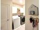 Cozy laundry room with white cabinets and floral wallpaper, offering style and functionality at 591 Black Eagle Dr, Groveland, FL 34736