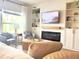 Cozy living room with a modern fireplace, large window, and comfortable seating at 591 Black Eagle Dr, Groveland, FL 34736