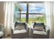 Cozy corner with two chairs, throw pillows, and natural light from a large window at 591 Black Eagle Dr, Groveland, FL 34736