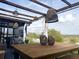 Inviting covered patio featuring stylish wicker lighting and a rustic wooden table, perfect for outdoor relaxation with picturesque views at 591 Black Eagle Dr, Groveland, FL 34736