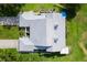 Aerial view showcases the tile roof, lush lawn, and long driveway of this well-maintained property at 6048 Topsail Rd, Lady Lake, FL 32159