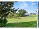 Lush backyard features mature trees and landscaping, offering serene outdoor views and privacy at 6048 Topsail Rd, Lady Lake, FL 32159