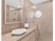 Stylish bathroom featuring tiled shower with glass door, unique window and modern vanity at 6048 Topsail Rd, Lady Lake, FL 32159