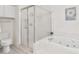 Bright bathroom featuring a glass-enclosed shower, a separate soaking tub, and white tiled flooring at 6048 Topsail Rd, Lady Lake, FL 32159