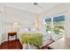 Bright bedroom with hardwood floors, large window, and view of the landscaped yard at 6048 Topsail Rd, Lady Lake, FL 32159