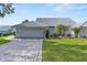 A lovely home featuring a pristine two-car garage, a brick driveway, and well-manicured landscaping at 6048 Topsail Rd, Lady Lake, FL 32159