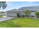 A lovely home featuring a pristine two-car garage, a brick driveway, and well-manicured landscaping at 6048 Topsail Rd, Lady Lake, FL 32159