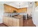 Spacious kitchen with wood cabinets, granite countertops, stainless steel appliances, hardwood floors, and island sink at 6048 Topsail Rd, Lady Lake, FL 32159