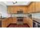 Bright kitchen with wooden cabinets, stainless steel appliances, granite countertops, and hardwood floors at 6048 Topsail Rd, Lady Lake, FL 32159
