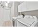 This laundry room features a modern washer and dryer with overhead cabinets for storage at 6048 Topsail Rd, Lady Lake, FL 32159