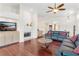 Cozy living room featuring a fireplace, hardwood floors, and comfortable couches perfect for relaxation at 6048 Topsail Rd, Lady Lake, FL 32159