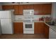 Traditional kitchen featuring brown cabinets, white appliances, and a laminate countertop at 610 Swallow Ct, Apopka, FL 32712