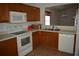 Kitchen featuring wooden cabinetry and white appliances at 610 Swallow Ct, Apopka, FL 32712