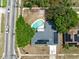 Aerial view of a property featuring a backyard pool, modern solar panels, and tree coverage at 6221 Ambassador Dr, Orlando, FL 32808