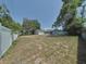 A spacious backyard surrounded by a white vinyl fence and greenery at 6221 Ambassador Dr, Orlando, FL 32808
