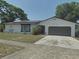 Charming single-story home featuring a two-car garage, well-maintained lawn, and mature trees at 6221 Ambassador Dr, Orlando, FL 32808