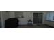 A covered patio with grill, table, sliding door, and window all along the home's exterior at 6221 Ambassador Dr, Orlando, FL 32808