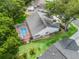 Overhead view of the backyard with a pool enclosed by a screen, complemented by lush green lawns and mature trees at 628 San Pedro Dr, The Villages, FL 32159