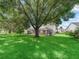 Spacious backyard featuring a screened-in pool and large shade trees creating a serene outdoor space at 628 San Pedro Dr, The Villages, FL 32159