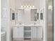 Bright bathroom with double vanities, pristine white cabinets, and stylish mirrors at 628 San Pedro Dr, The Villages, FL 32159