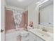 Cozy bathroom featuring pink tile, a shower-tub combo, and white marble countertop at 628 San Pedro Dr, The Villages, FL 32159