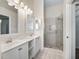 Bright bathroom featuring double sinks and a glass-enclosed shower at 628 San Pedro Dr, The Villages, FL 32159