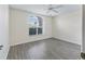Bright bedroom featuring a ceiling fan, a window with blinds, and gray wood-look flooring at 628 San Pedro Dr, The Villages, FL 32159
