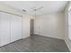 Bright bedroom features gray flooring, closet and a white ceiling fan at 628 San Pedro Dr, The Villages, FL 32159