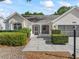 Charming home exterior featuring a covered entrance, manicured shrubs, and a well-maintained lawn at 628 San Pedro Dr, The Villages, FL 32159