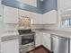 Stylish kitchen with stainless steel appliances, white subway tile backsplash, and dark hardwood floors at 628 San Pedro Dr, The Villages, FL 32159