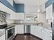 Well-lit kitchen with white cabinets, stainless steel appliances, and dark hardwood floors at 628 San Pedro Dr, The Villages, FL 32159