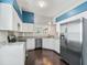 Modern kitchen features white cabinets, stainless steel appliances, and dark hardwood flooring at 628 San Pedro Dr, The Villages, FL 32159