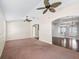 Spacious living area with high ceilings and neutral carpet, connecting to a bright dining space at 628 San Pedro Dr, The Villages, FL 32159