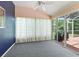 Enclosed sunroom with carpet, sliding glass doors overlooking the backyard, and white curtains at 628 San Pedro Dr, The Villages, FL 32159